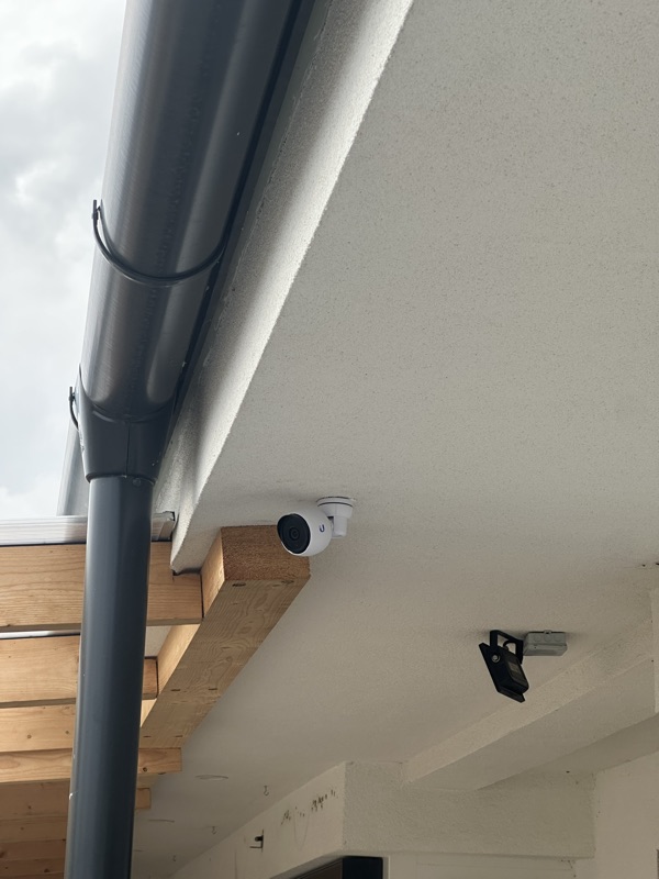 UniFi Protect kamera az eresz alatt kültéri fényvetővel