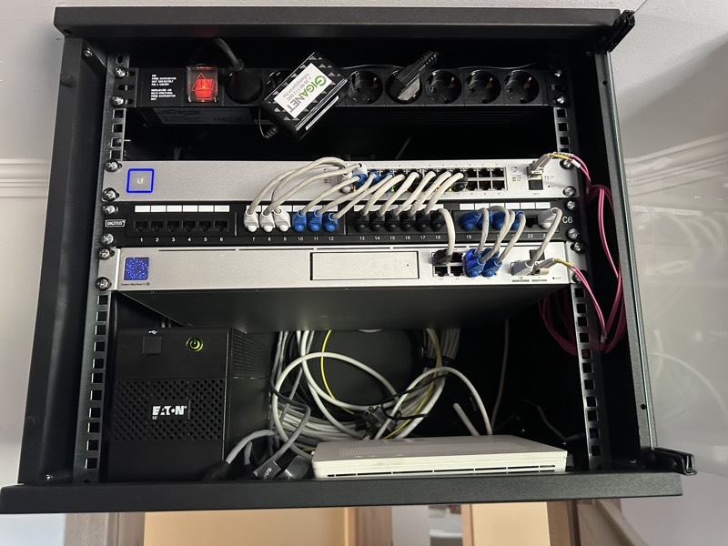 Rendezett UniFi rack szekrény switch-csel, patch panellel és szünetmentes táppal
